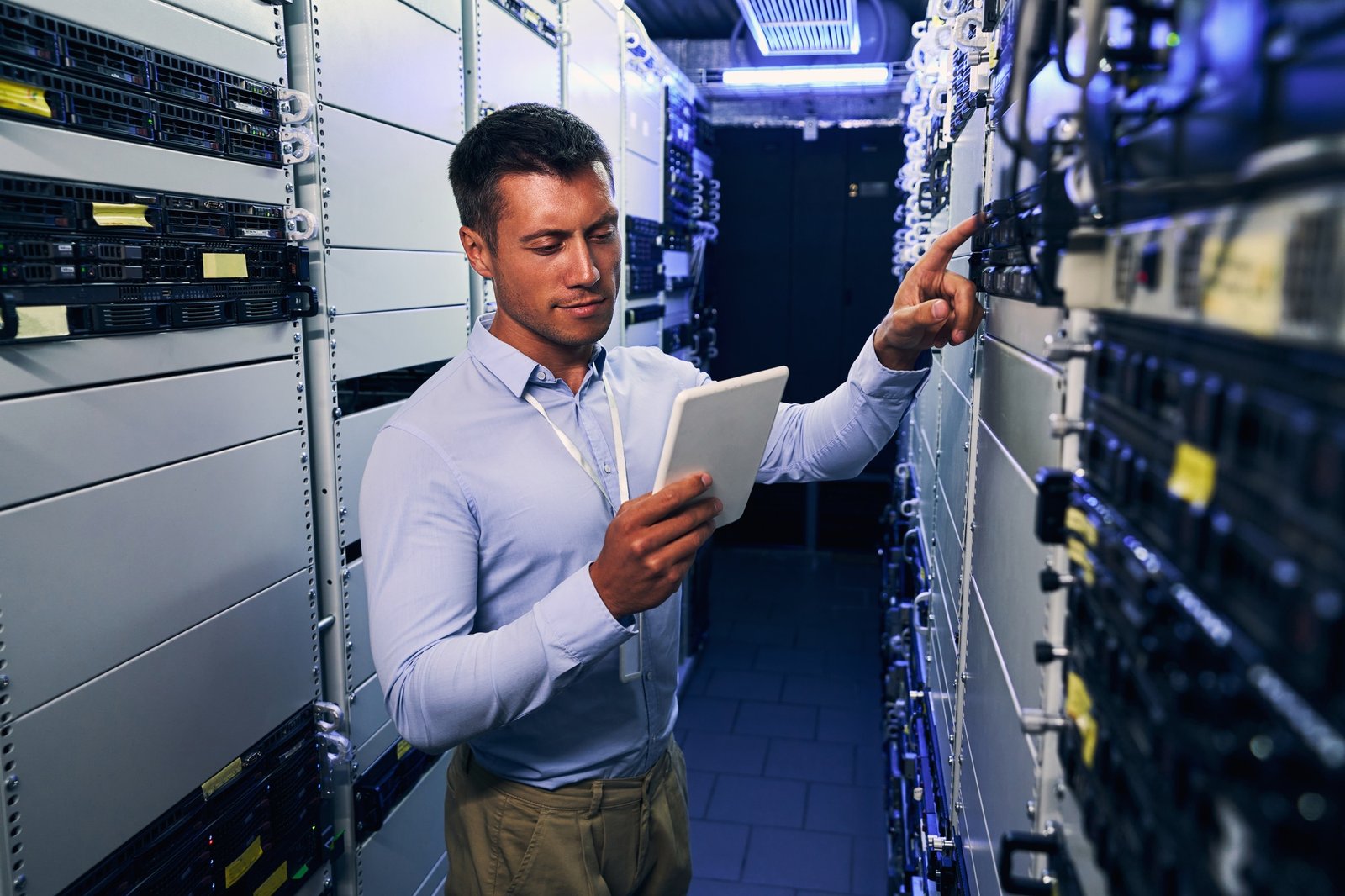 IT technician consulting tablet computer during preventive maintenance